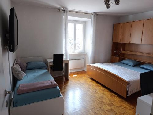 a bedroom with two beds and a desk and a tv at Silvo Apartments in Koper