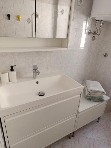 a white bathroom with a sink and a mirror at Silvo Apartments in Koper