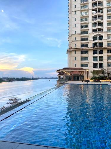 a large swimming pool next to a large building at Riverine Diamond Kuching in Kuching