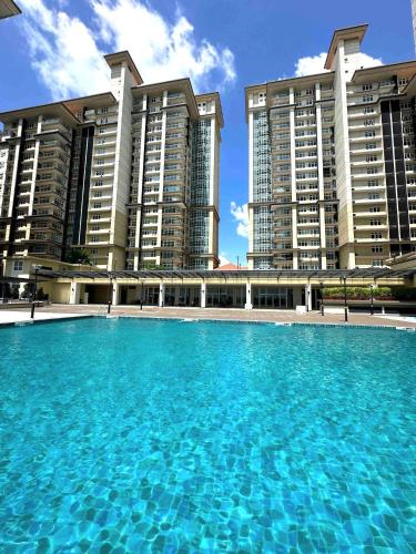 a large swimming pool in front of two tall buildings at Riverine Diamond Kuching in Kuching