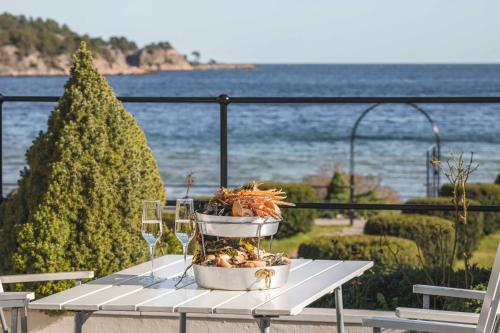 a table with a plate of food and wine glasses at Strand Hotel Fevik - by Classic Norway Hotels in Fevik