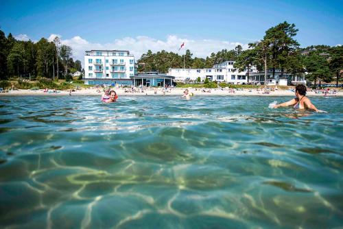 a group of people in the water at a beach at Strand Hotel Fevik - by Classic Norway Hotels in Fevik