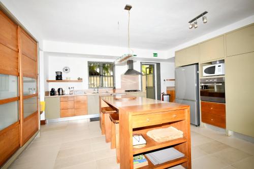 a kitchen with a wooden island in the middle at Villa Emerald in Post of Flacq