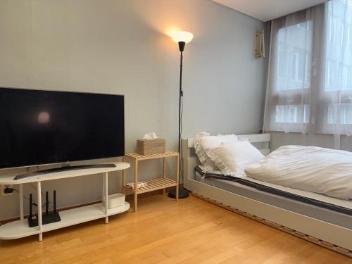 a bedroom with a bed and a flat screen tv at 4-3025 #GangnamStation, 5mins #K-Pop #Yeoksam, 3mins #Neflix #K-food #Seoul in Seoul