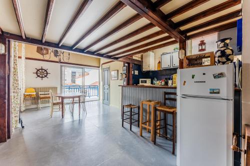 Il comprend une cuisine équipée d'un réfrigérateur et d'une table avec des chaises. dans l'établissement Loft familial Arcachon, à Arcachon