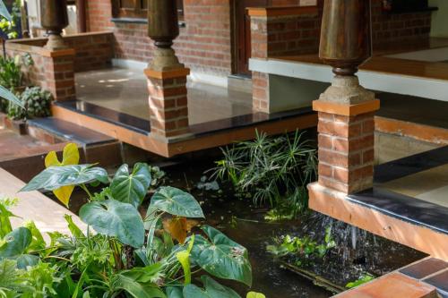 a pond in front of a building with a water fountain at Kerala Style Villa by JadeCapsAC4BHKFishpond in Yelahanka
