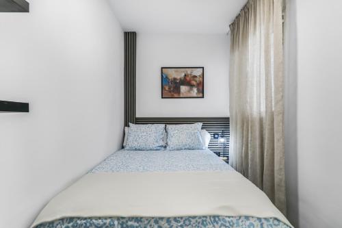a bedroom with a large bed with blue pillows at Santa Cruz Kiko Residences in Santa Cruz de Tenerife