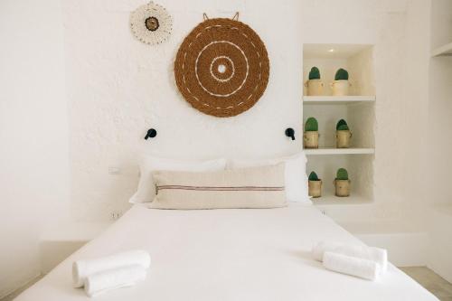 a white bedroom with a white bed and shelves at Corte Manfredi in Alessano