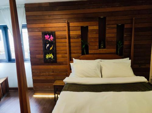 a bedroom with a bed with a wooden wall at mstay in Bangkok