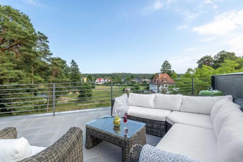 eine Terrasse mit einem weißen Sofa, Stühlen und einem Tisch in der Unterkunft Two-level Modern Apartment with Spacious Terrace - Ideal Place for the Holiday by Noclegi Renters in Wisełka