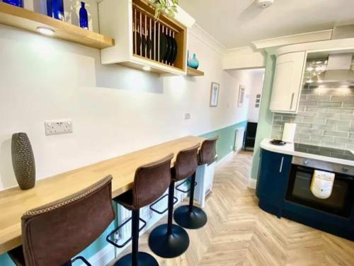 a kitchen with a wooden table and some chairs at 2 Bedroom Apartment with Garden, Close to Beach in Southend-on-Sea