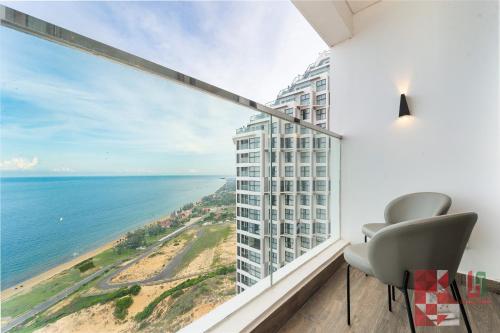 a room with a chair and a view of the ocean at Apec Mandala Mui Ne by LHG - Sea View, Infinity Pool, Alacarte, 17m to Bàu Trắng Bình Thuận in Mui Ne