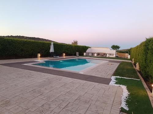 a swimming pool in a yard with a patio at Evelina's suite in Artemida