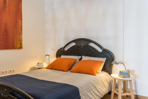sypialnia z łóżkiem z pomarańczowymi poduszkami w obiekcie Art apartment in downtown Porto w Porto