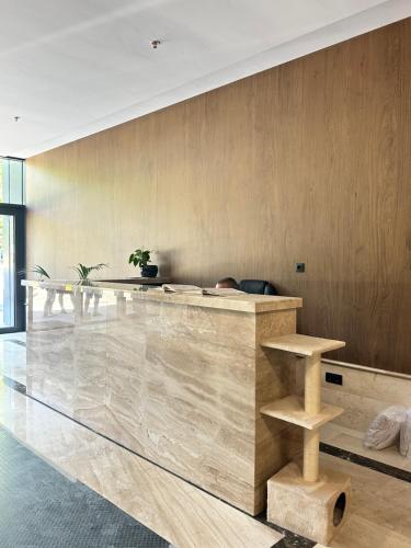 a lobby with a marble counter with a person sitting at it at Chantrer in Burgas