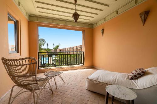 a living room with a couch and a chair and a large window at Jaal Riad Resort in Marrakech