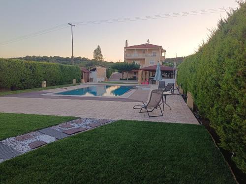 a backyard with a swimming pool and a house at Evelina's studio in Artemida
