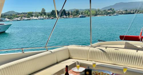 a seat on a boat with a table on the water at Stunning Motor Yacht in Corfu in Gouvia