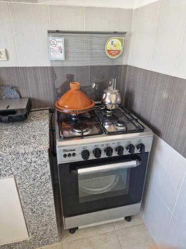 a kitchen with a stove with a pot on it at appartement imi ouadar in Imi Ouaddar