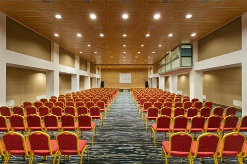 an empty conference room with red chairs and a screen at Duja Bodrum in Torba