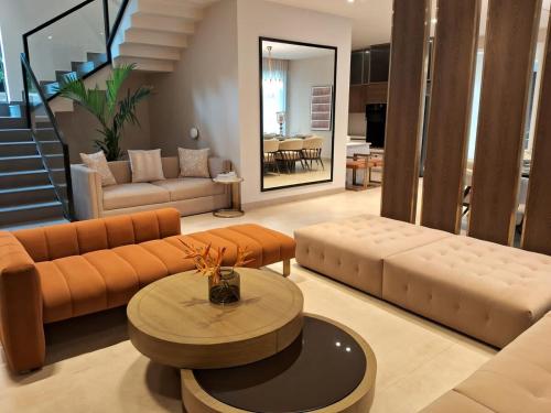 a living room with a couch and a table at Villa Takiana - 4BHK pvt pool, Gym, 5mins to beach in Anjuna