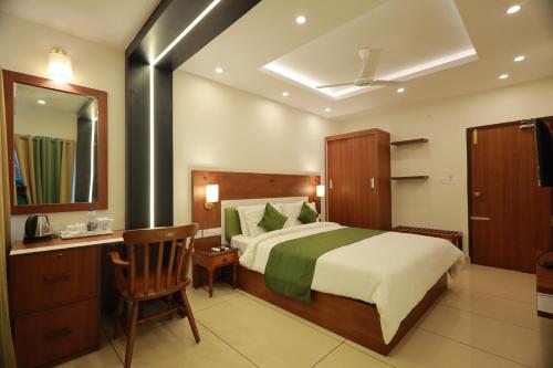 a bedroom with a bed and a desk and a mirror at KTDC Aqualand in Kollam