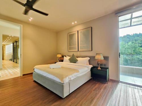 a bedroom with a bed and a large window at Villa Takiana - 4BHK pvt pool, Gym, 5mins to beach in Anjuna