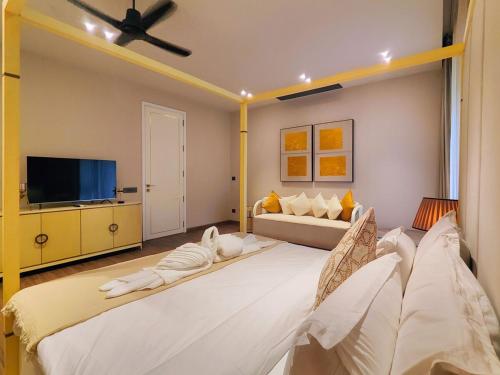 a living room with two beds and a flat screen tv at Villa Takiana - 4BHK pvt pool, Gym, 5mins to beach in Anjuna