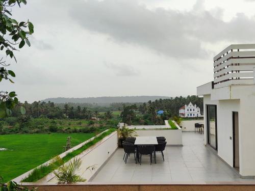 a balcony with a table and chairs on it at Villa Takiana - 4BHK pvt pool, Gym, 5mins to beach in Anjuna