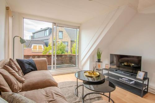 a living room with a couch and a tv at Stay de Laat in Alkmaar