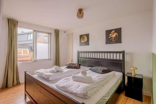 a bedroom with two beds and a window at Stay de Laat in Alkmaar