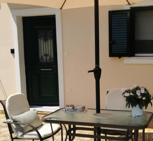 tavolo e sedie in una stanza con porta verde di Sunny Patio Studio Corfu ! ad Alepoú
