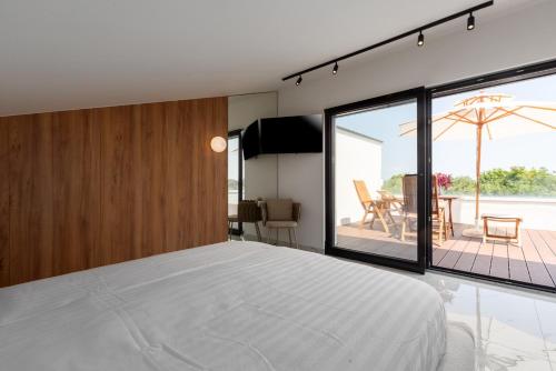 a bedroom with a large white bed and a patio at Villa Verana with pool in Savudrija