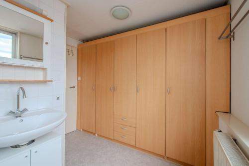 a bathroom with wooden cabinets and a sink at Stay de Laat in Alkmaar
