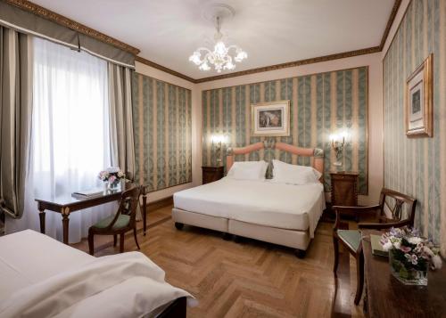 a hotel room with a bed and a table and chairs at Due Torri Hotel in Verona