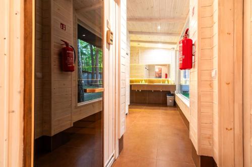 a hallway leading to a kitchen with red fire extinguings at Letnisko BAJKA in Iława