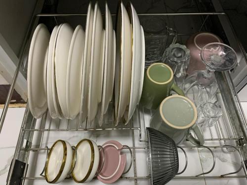 a rack with plates and cups in a kitchen at Cozy Aesthetic 2BR 3 storey Home with Rooftop in San Mateo