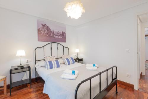 a bedroom with a large bed with two towels on it at Taosa - baskeyrentals in Zumaia