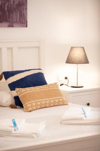 a white bed with two pillows and a lamp at Taosa - baskeyrentals in Zumaia