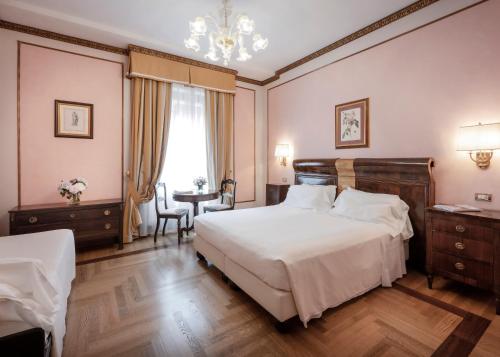 a bedroom with two beds and a chandelier at Due Torri Hotel in Verona