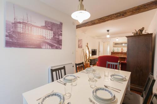 a dining room with a white table with plates on it at Taosa - baskeyrentals in Zumaia