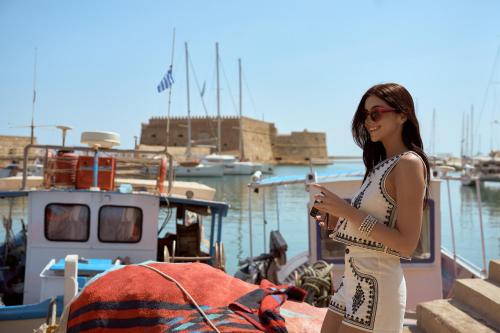 a woman standing on a boat in the water at Rocca a Mare Heraklion - Handwritten Collection in Heraklio Town
