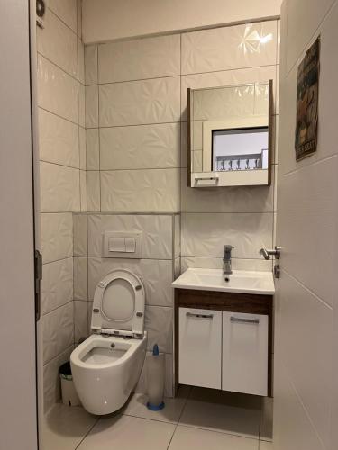 mała łazienka z toaletą i umywalką w obiekcie Sunset Apartment w Prisztinie