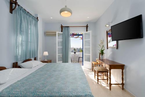 a bedroom with a bed and a desk and a television at Proteas Hotel in Kamari