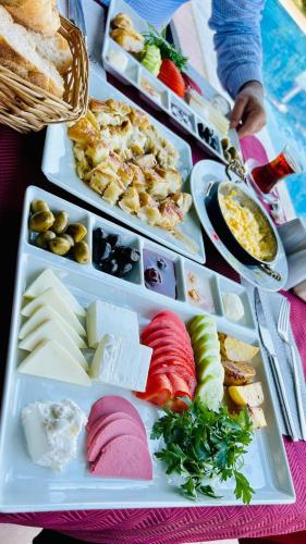 une table avec plusieurs plateaux de différents types de denrées alimentaires dans l'établissement jasmine otel, à Kemer