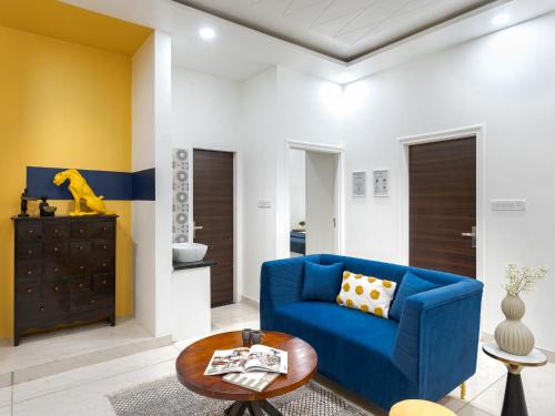 a living room with a blue couch and a table at Thamosa Stays in Jaipur