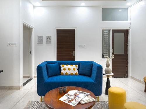 a blue couch in a living room with a table at Thamosa Stays in Jaipur