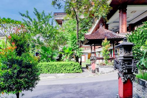 a house with a red pole in front of it at Collection O Bali near Terminal Ubung formerly Batukaru Garden Hotel in Kesiman