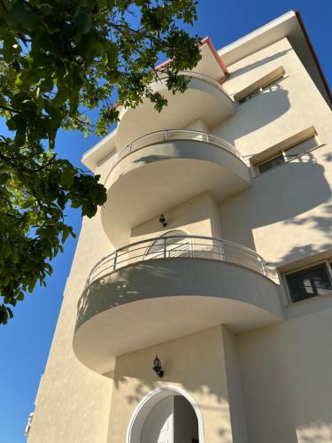 a building with a spiral staircase on the side of it at Kings Castle Sea View Apartments in Orikum