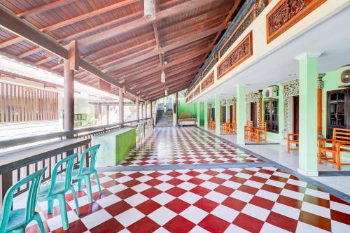 a corridor of a building with a checkered floor at Collection O Bali near Terminal Ubung formerly Batukaru Garden Hotel in Kesiman
